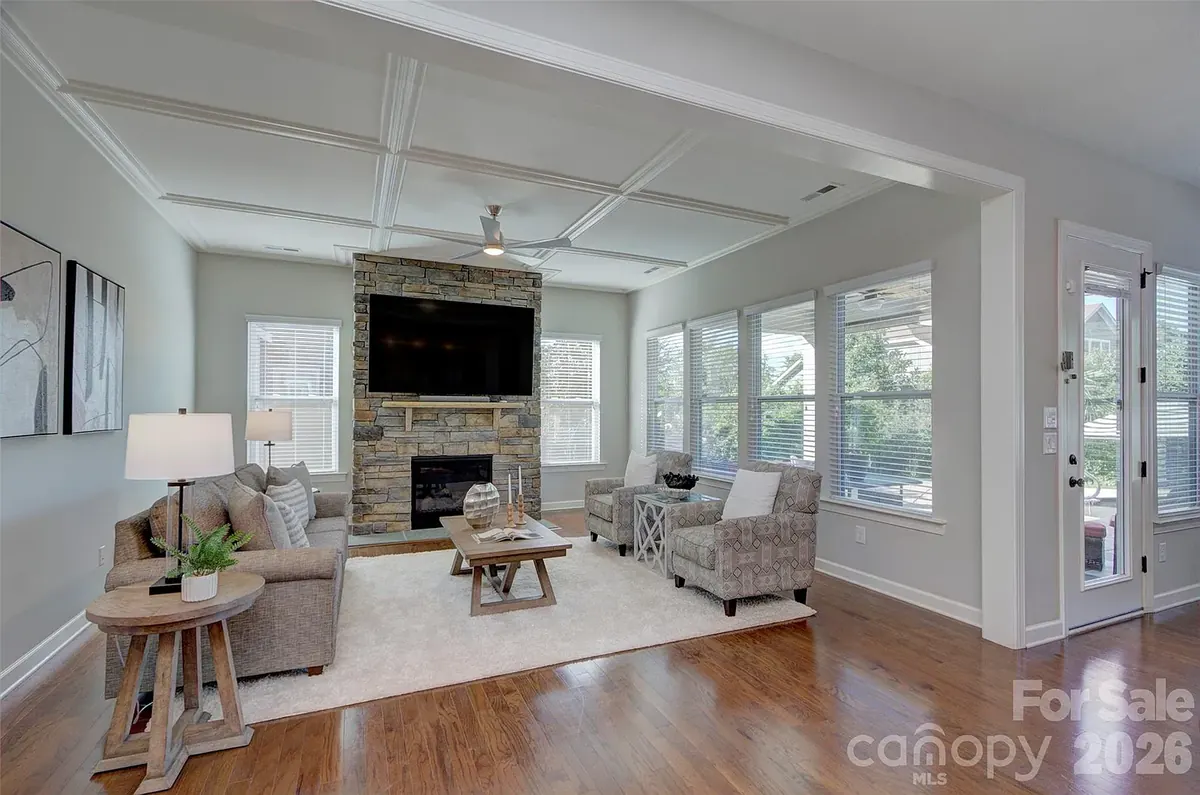 Bright living room with a stone fireplace and a wall of windows